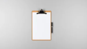 Πινακίδα κλιπ με λευκό χαρτί και στυλό σε γκρι φόντο